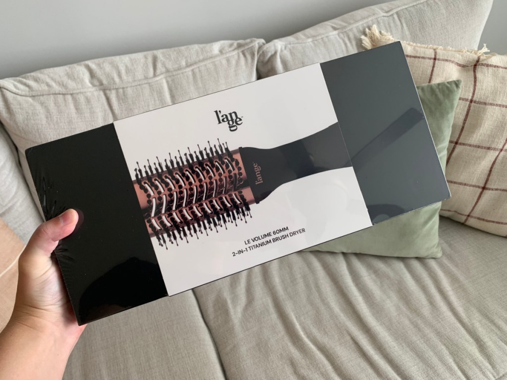 hand holding a lange le volume dryer hair brush in the box