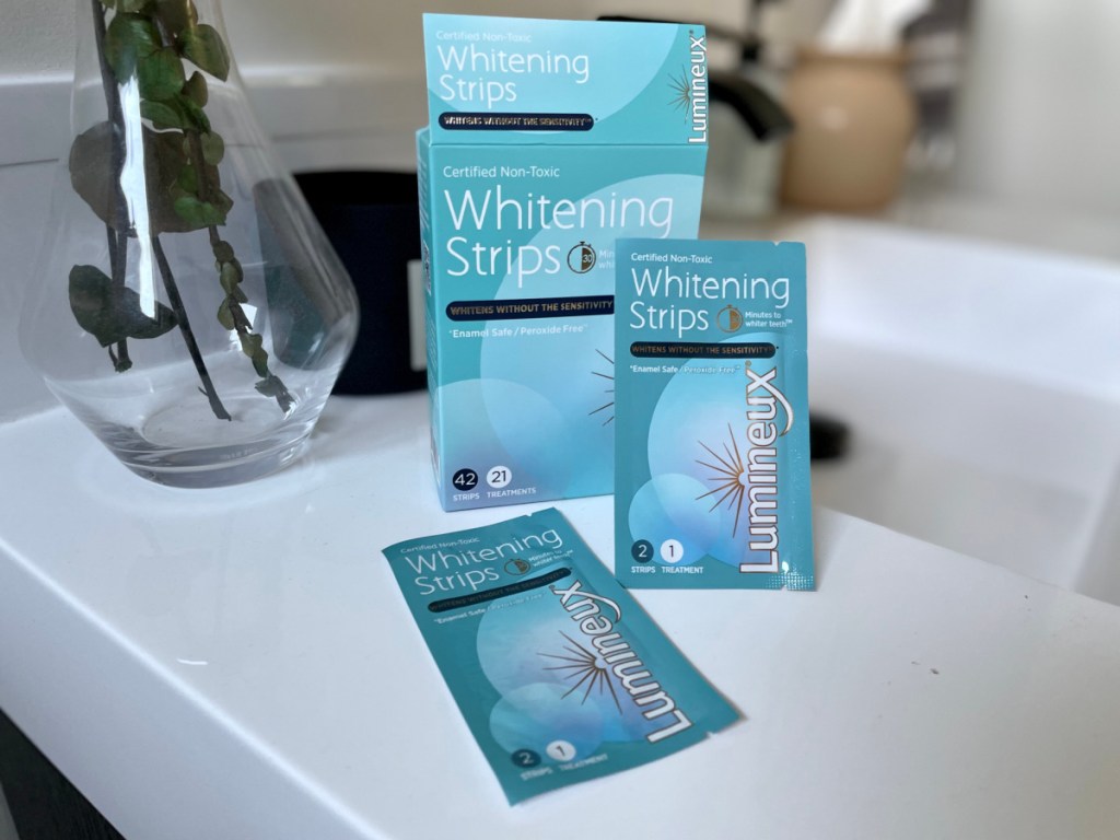 lumineux whitening strips in and out of the box on a bathroom sink