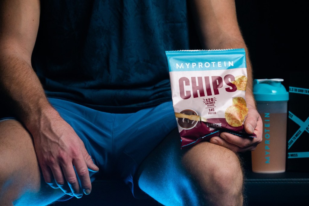 man holding bag of chips while working out