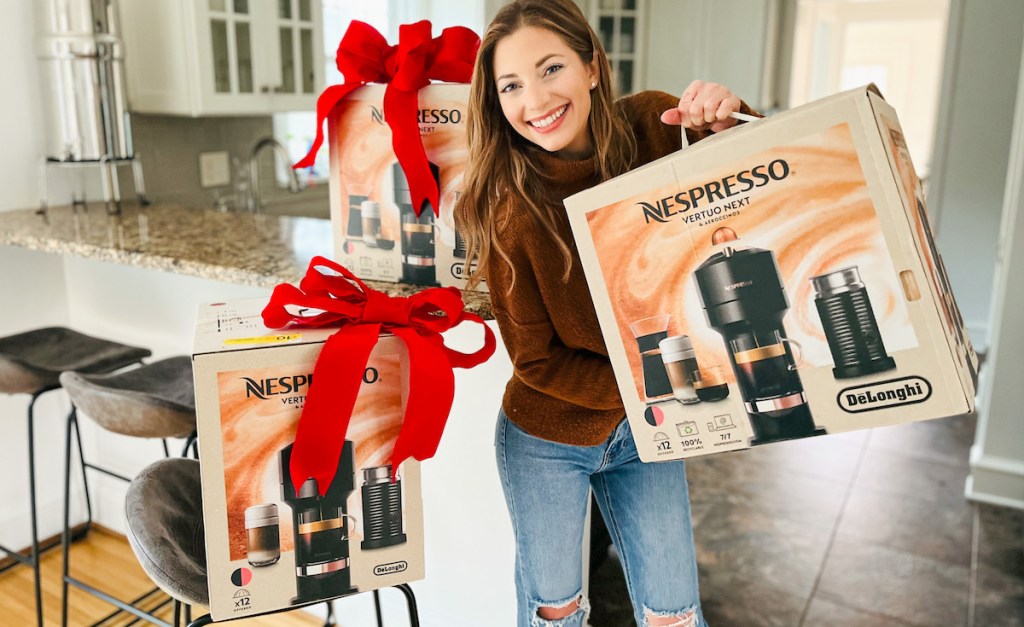 woman holding up nespresso boxes with big red bows on top
