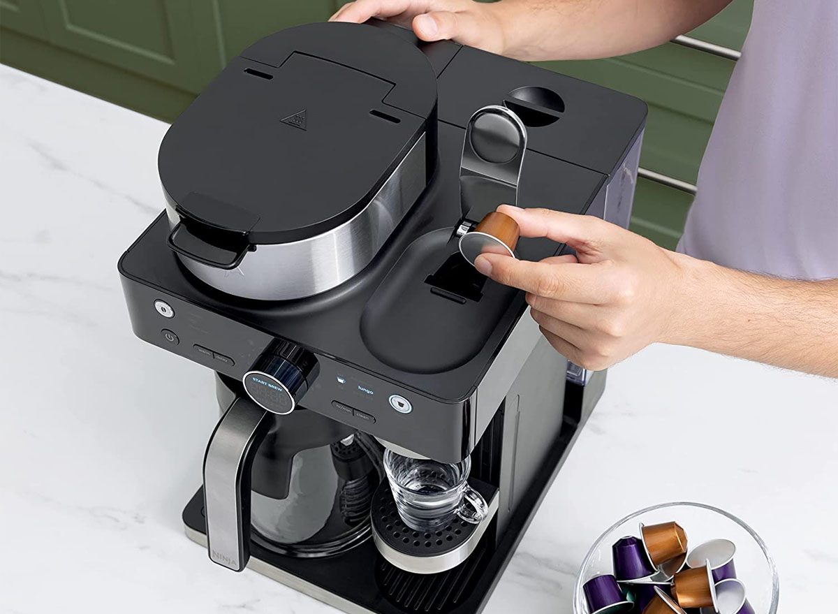 hand putting coffee pod in ninja coffee system
