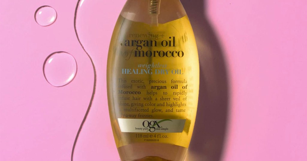 ogx aragon healing oil bottle on pink background