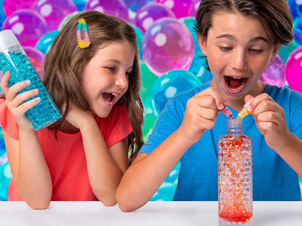 two kids playing with orbeez kit