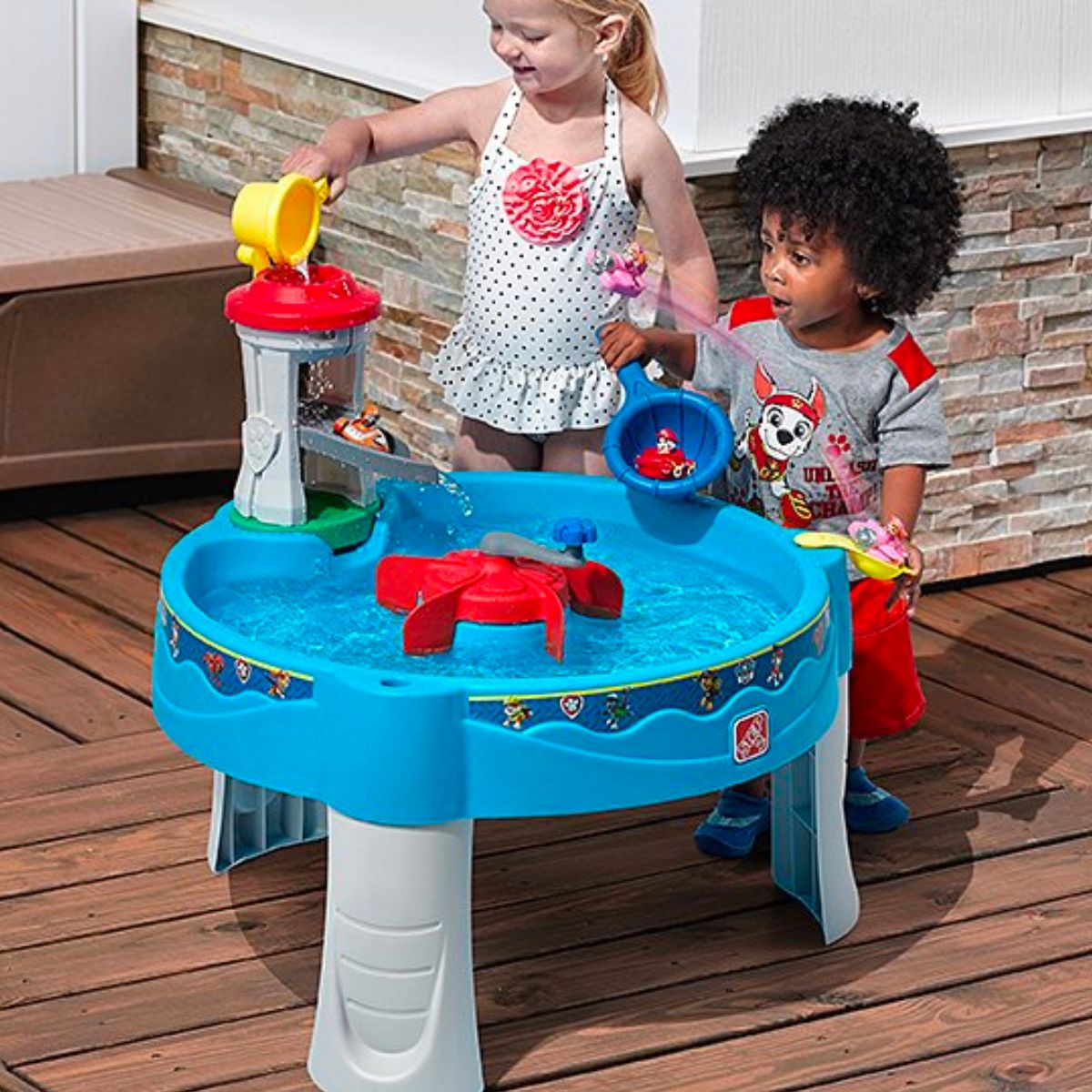 two toddlers playing at paw patrol water table 