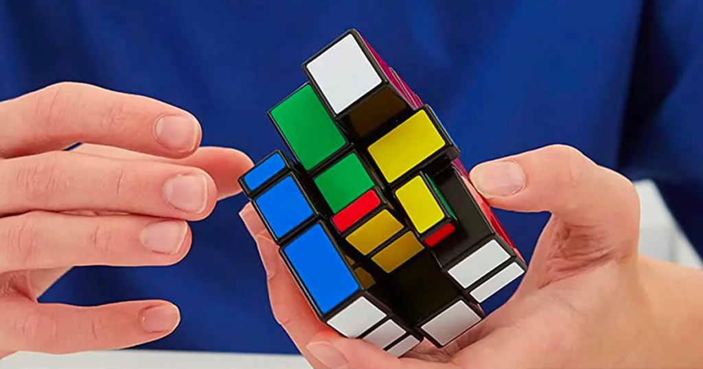 hands holding rubiks cube puzzle toy