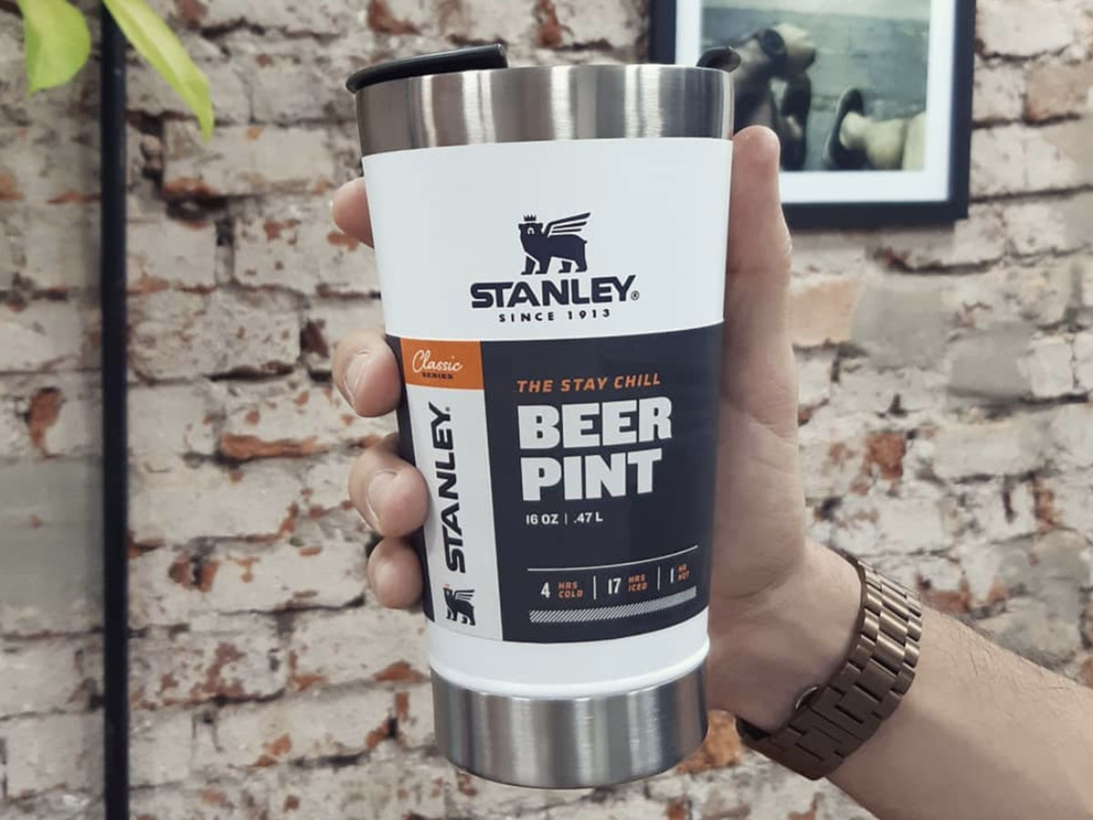 hand holding white stanley beer pint