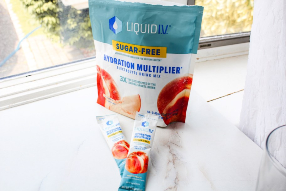 package of sugar free liquid iv hydration packets next to the bag sitting on a windowsill