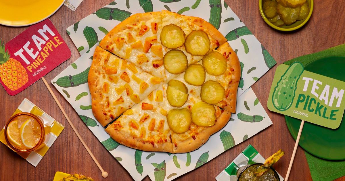 a half pineapple, half pickle pizza with signs on the right and left declaring team pineapple and team pickleteam pickle or pineapple