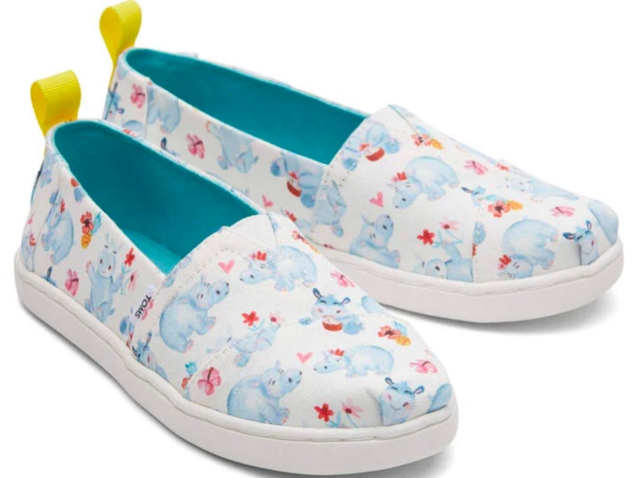 A pair of white and hippo patterned toms shoes