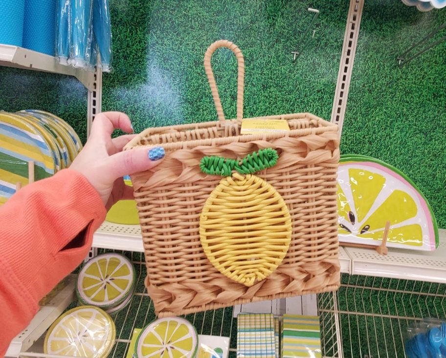 womans hand displaying a wicker utensil caddy