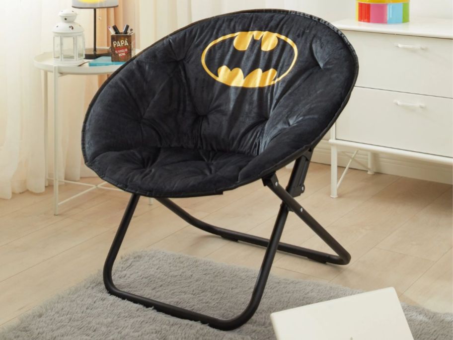 black oversized saucer chair with the Batman logo on it in a bedroom