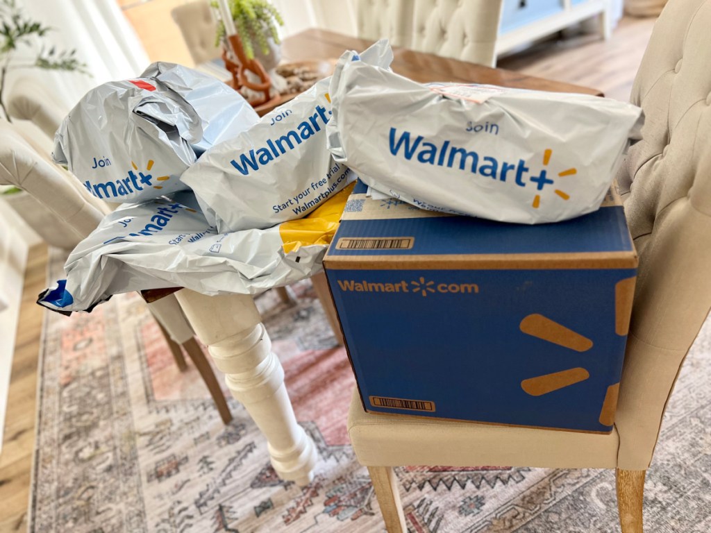 various walmart shipping packages stacked on a chair and table