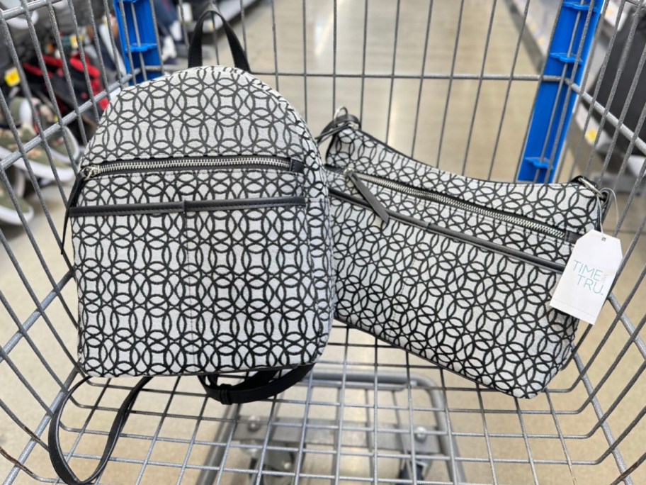 black and white printed backpack and shoulder bag in Walmart shopping cart