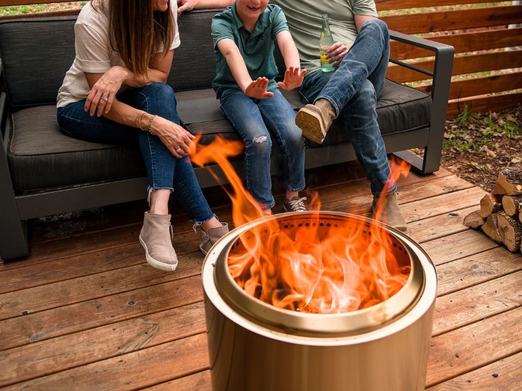 Family sitting on a bench by a Solo Stove Bonfire 2.0 w/ Stand, Starter Packs and Pellet Adapter