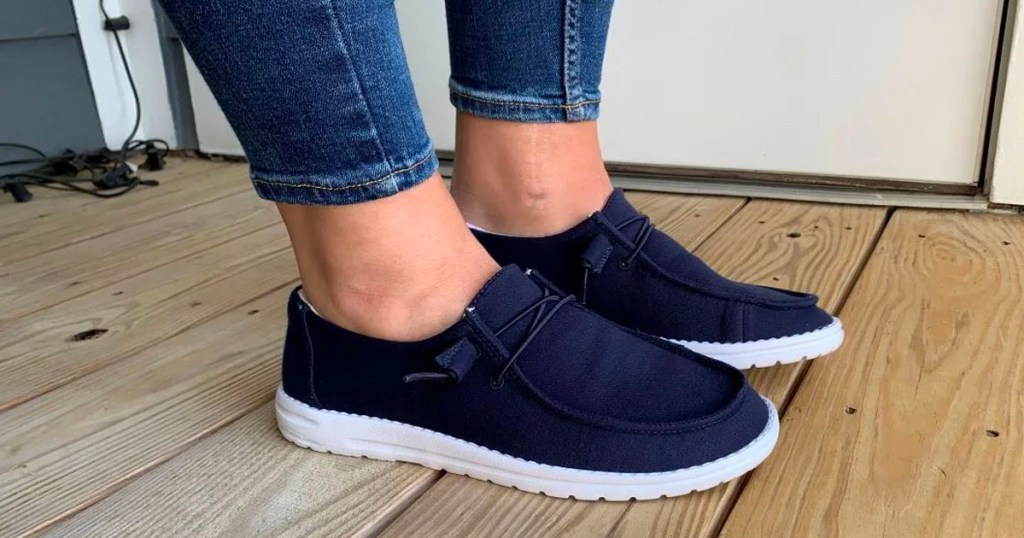 person wearing navy blue canvas shoes 