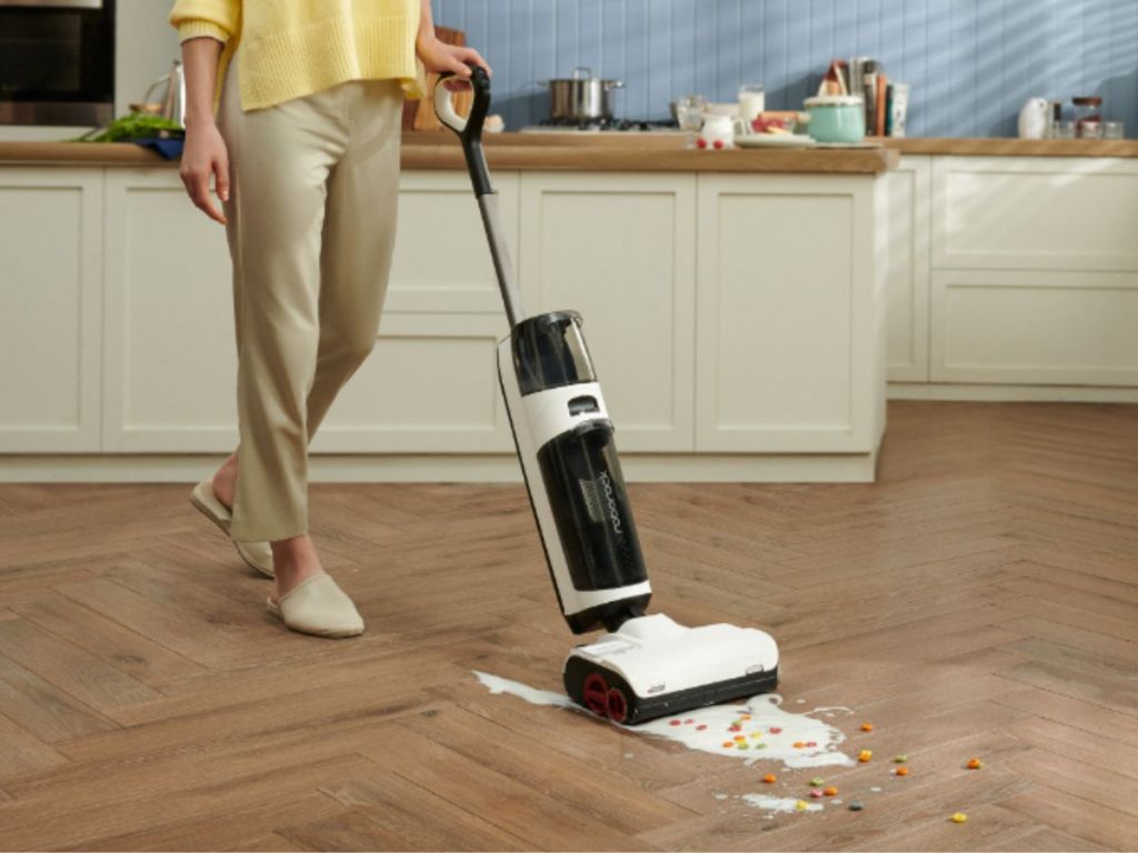 Roborock Dyad Pro Wet and Dry Vacuum Cleaner shown vacuuming up milk and cereal in a kitchen