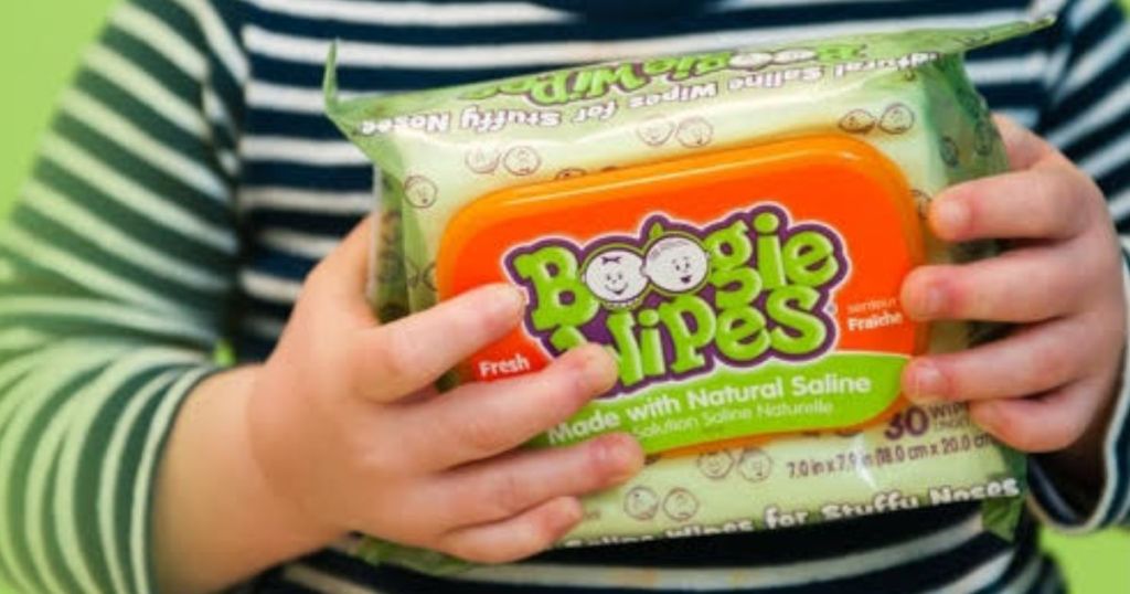 Baby holding a pack of Boogie wipes Fresh Scent