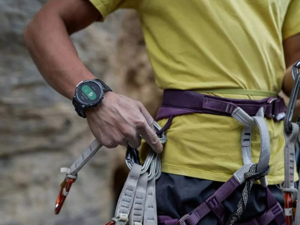 person latching safetly hook to belt wearing smartwatch