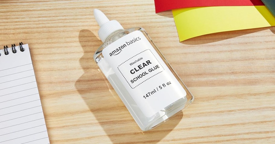 small bottle of amazon basics clear school glue on desk