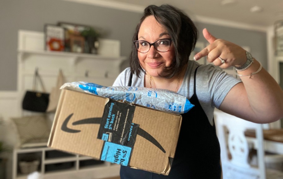 Woman pointing at her Amazon Prime Packages in her hand, one of the Amazon prime perks
