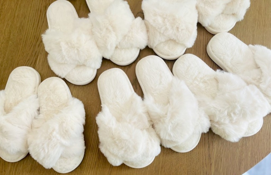 tons of white slippers sitting on wood table