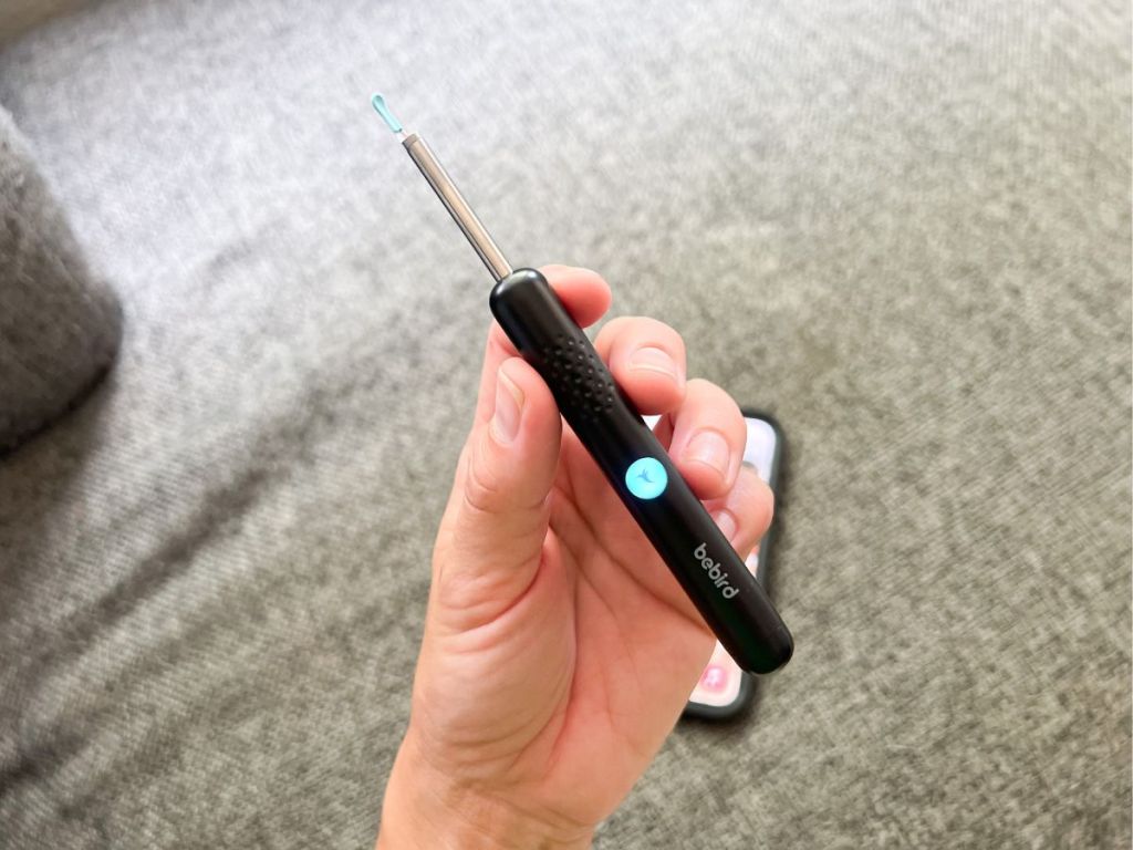 person holding ear removal wand 