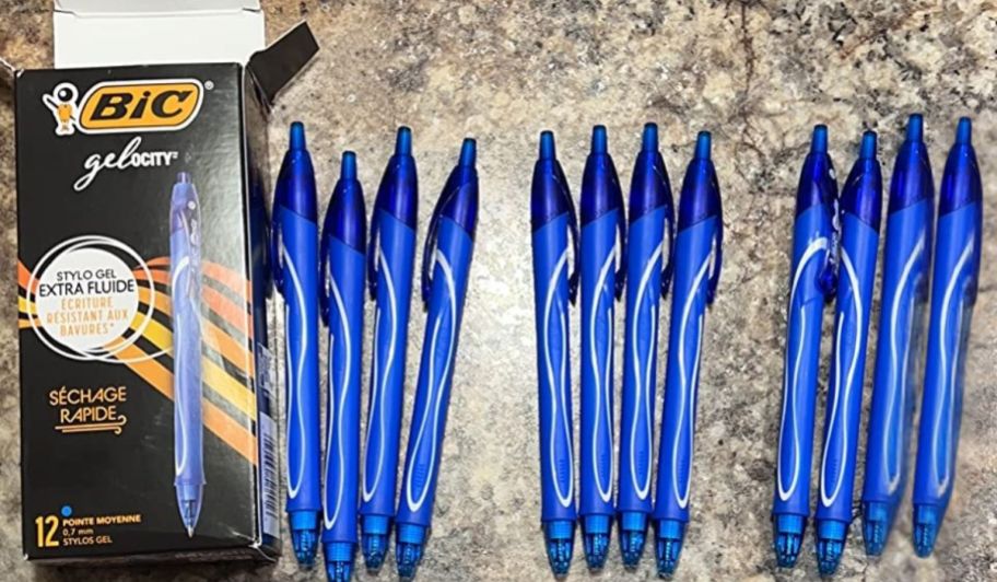 Box of BIC gelocity blue pens next to a stack of them