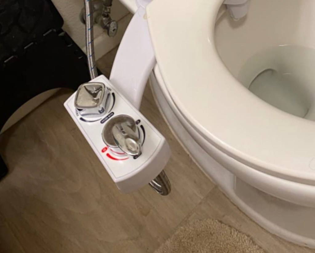 close up of butt buddy bidet spa on side of toilet