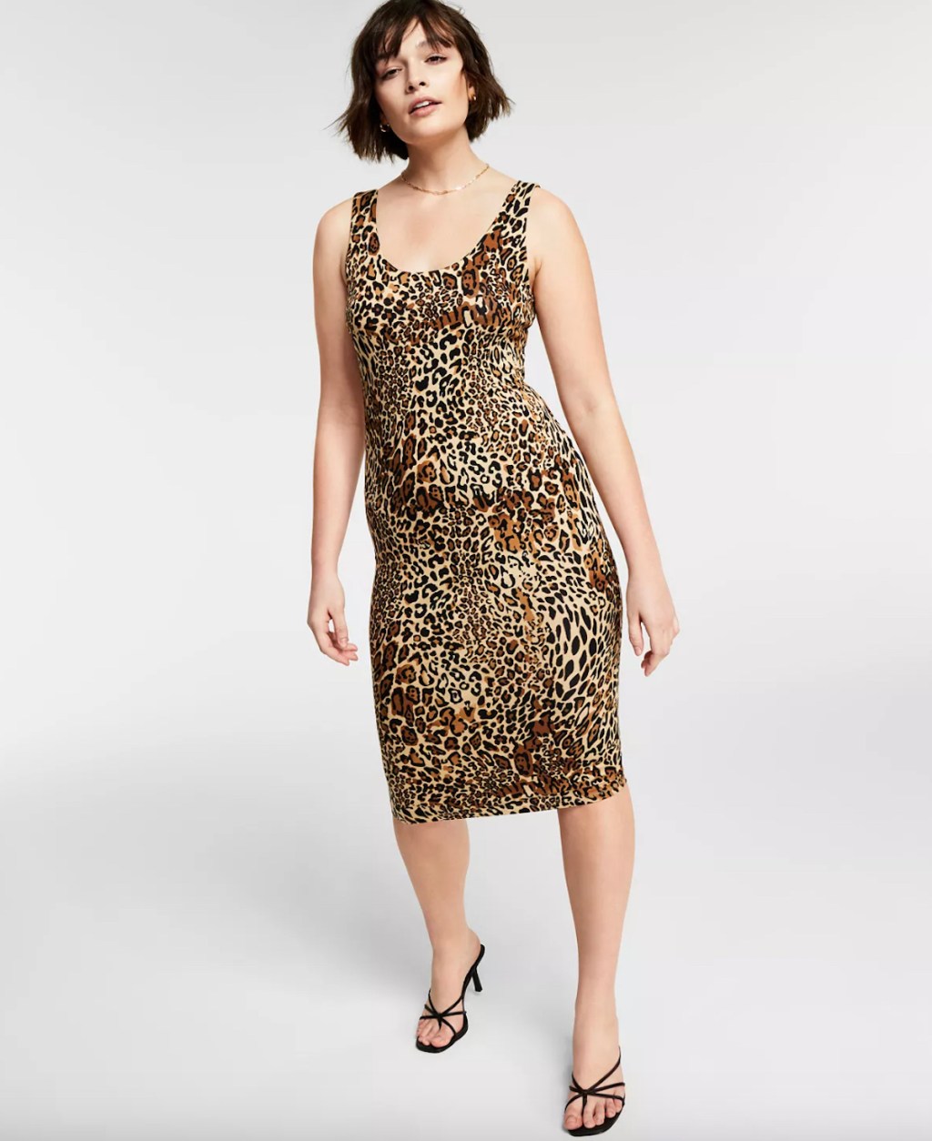 woman posing in tank leopard dress in light gray room