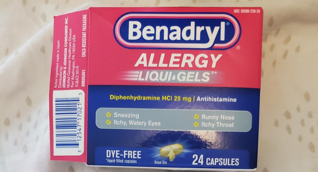 Benadryl liquid gel allergy medicine 24 count opened and displayed on a bedsheet