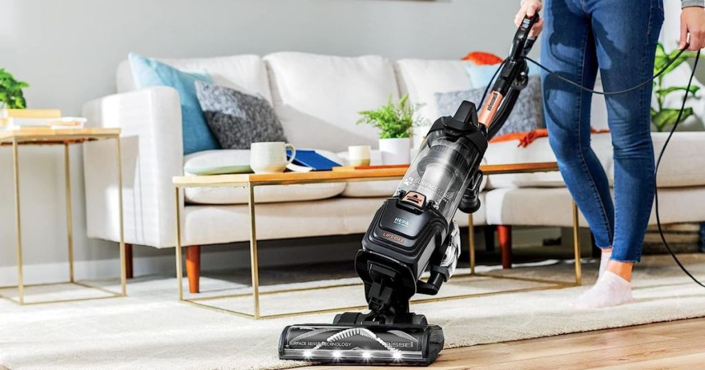 person vacuuming carpet and wood floor