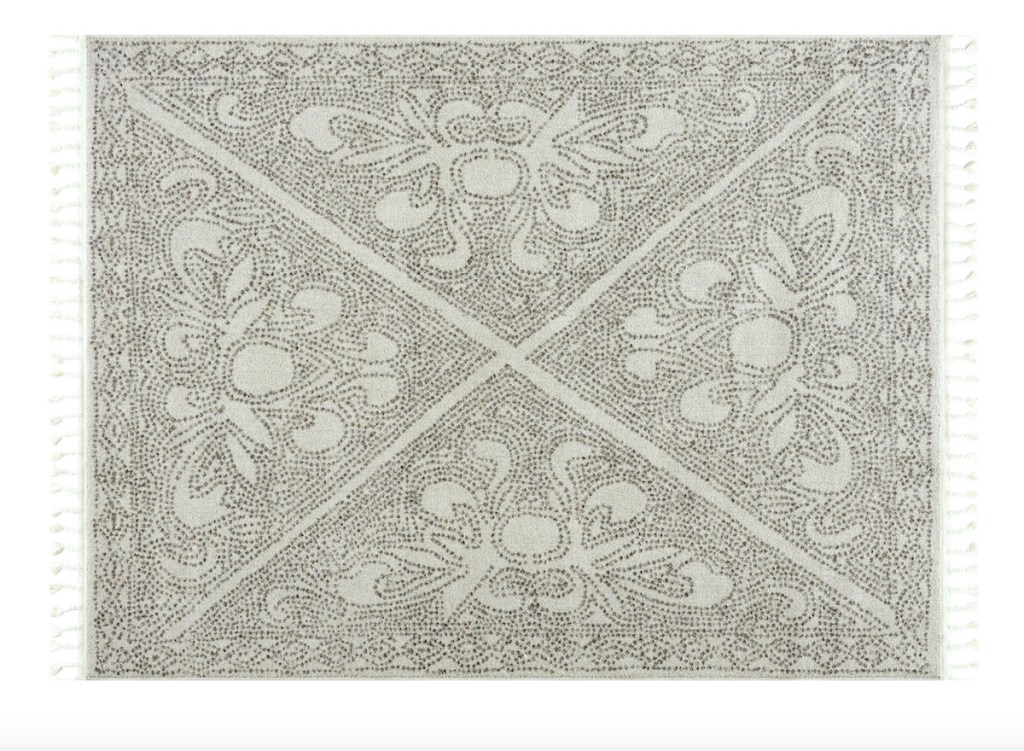 gray and white pattern rug on white background with tassels
