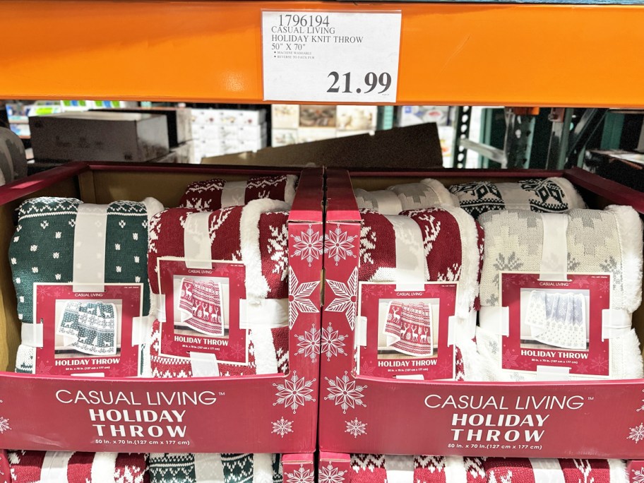 display of green, red, and white holiday throw blankets in store