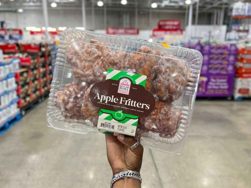 a hand holding a package of apple fritters