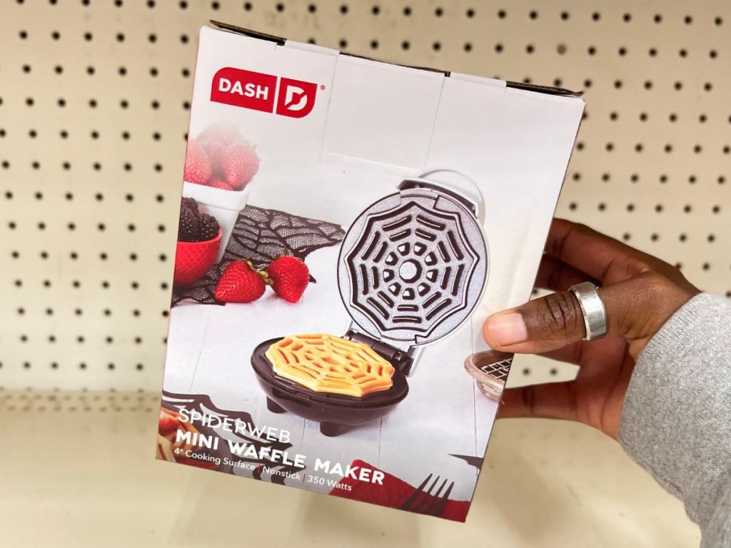 A hand holding a Dash Mini Wafflemaker Spiderweb