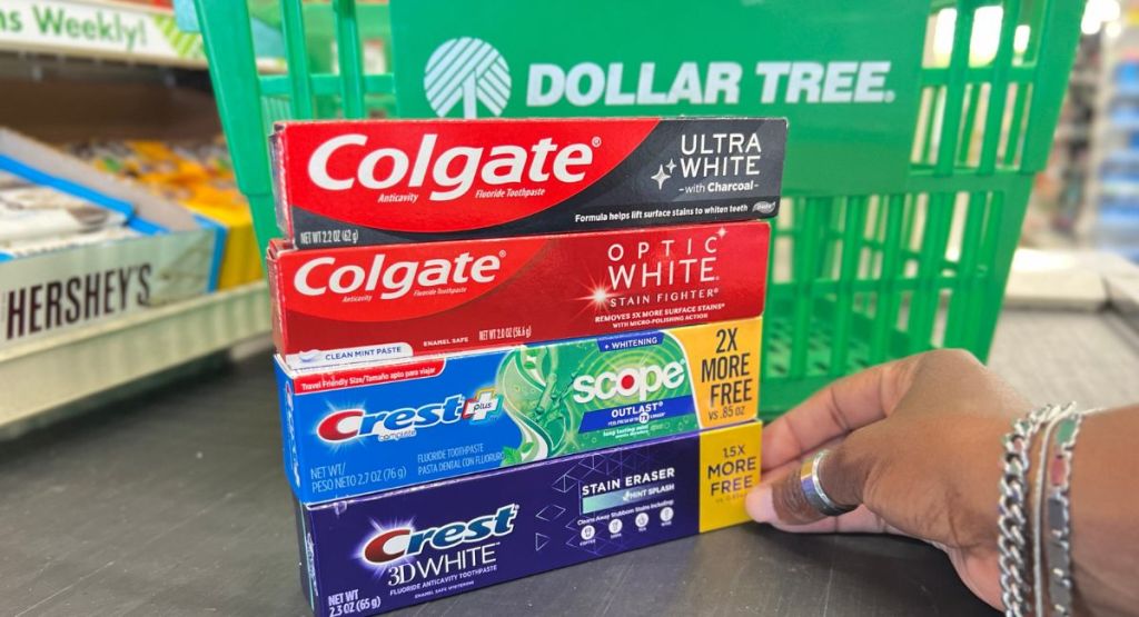 4 boxes of toothpaste on a conveyer belt with a Dollar Tree basket