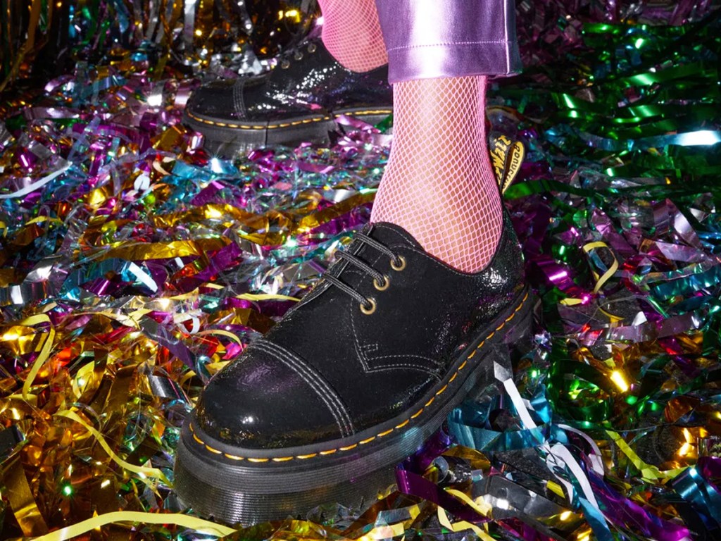 person wearing black platform shoes standing on top of colorful streamers