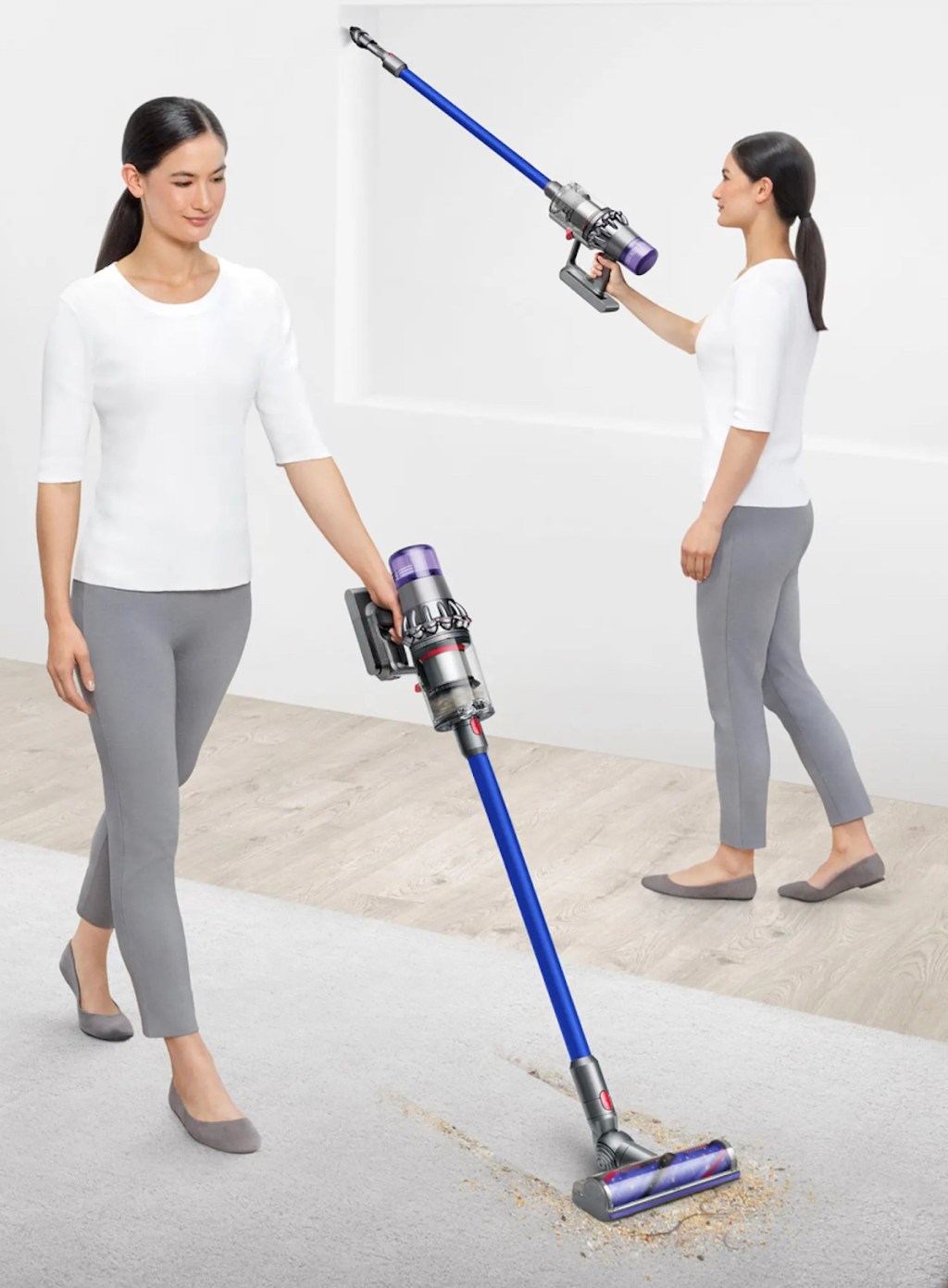 woman using dyson vacuum on floor with crumbs and white walls
