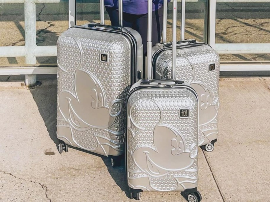 three matching silver mickey mouse luggage pieces