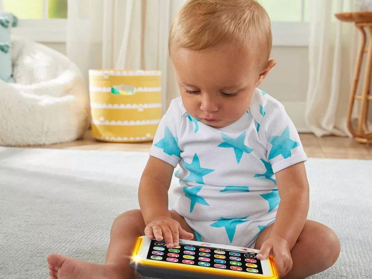 baby playing with toy tablet