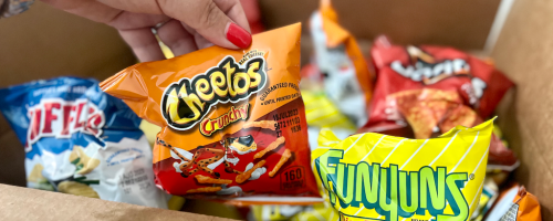Hand holding up a bag of Cheetos chips