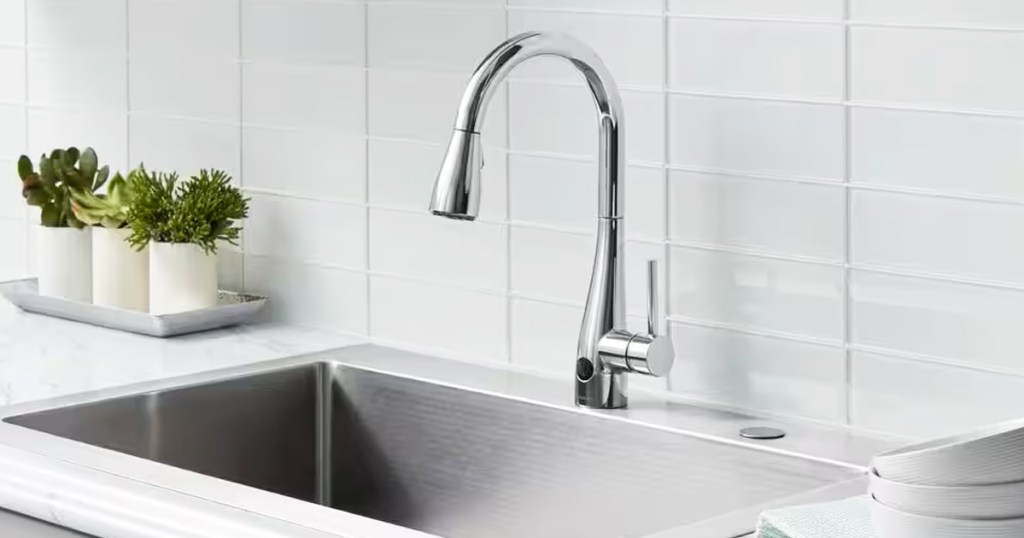 silver faucet at stainless steel kitchen sink