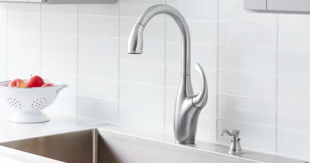 silver faucet with matching soap dispenser at stainless steel sink