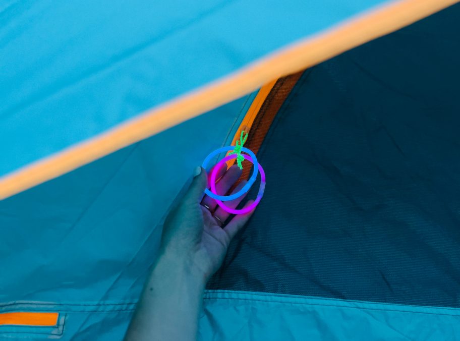 using glow sticks to illuminate a tent zipper, one of our favorite camping hacks