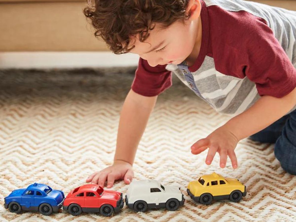 Child playing with 4 Green Toys mini cars
