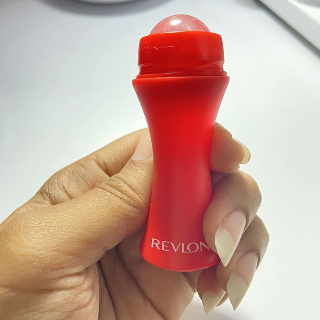 woman's hand holding a Revlon Skin Reviving Roller with Rose Quartz