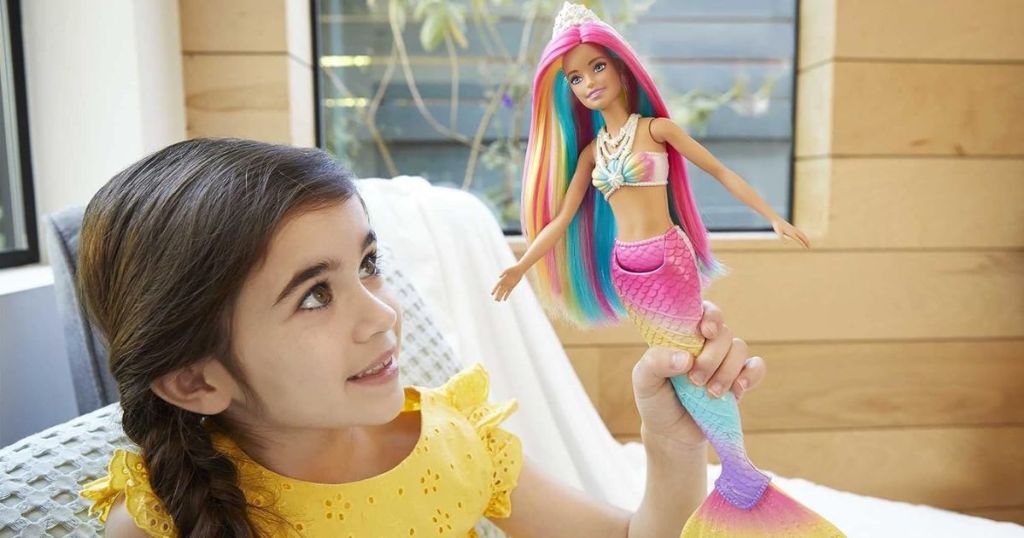 little girl playing with a Barbie Dreamtopia Mermaid doll