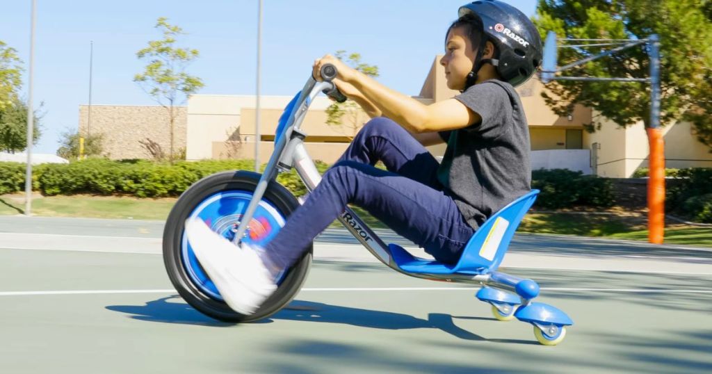 little boy riding a Razor RipRider 360 Caster Trike on a basketball court