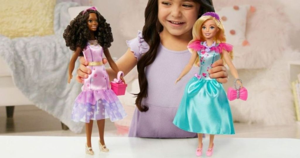Little girl playing with My First Barbie and accessories