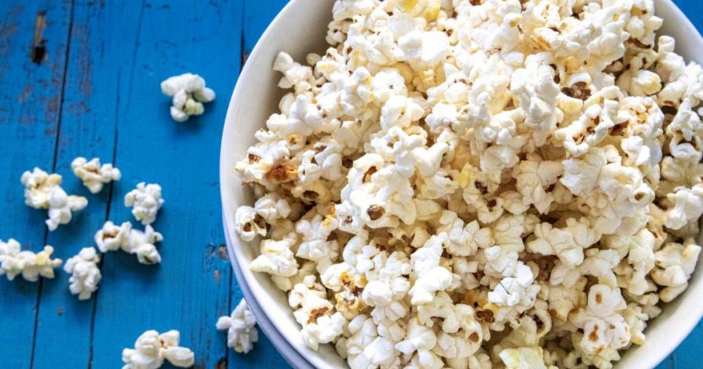 Bob's Red Mill Whole White Popcorn, 30-ounce shown popped in a bowl on a blue table